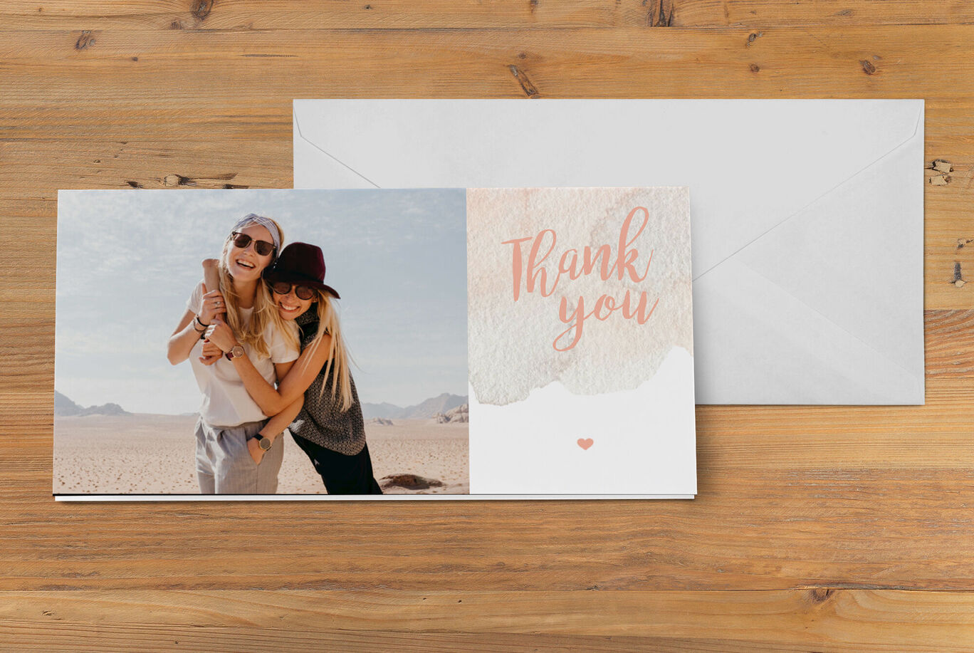 Two women hug, holding a thank you card under a heartfelt message.